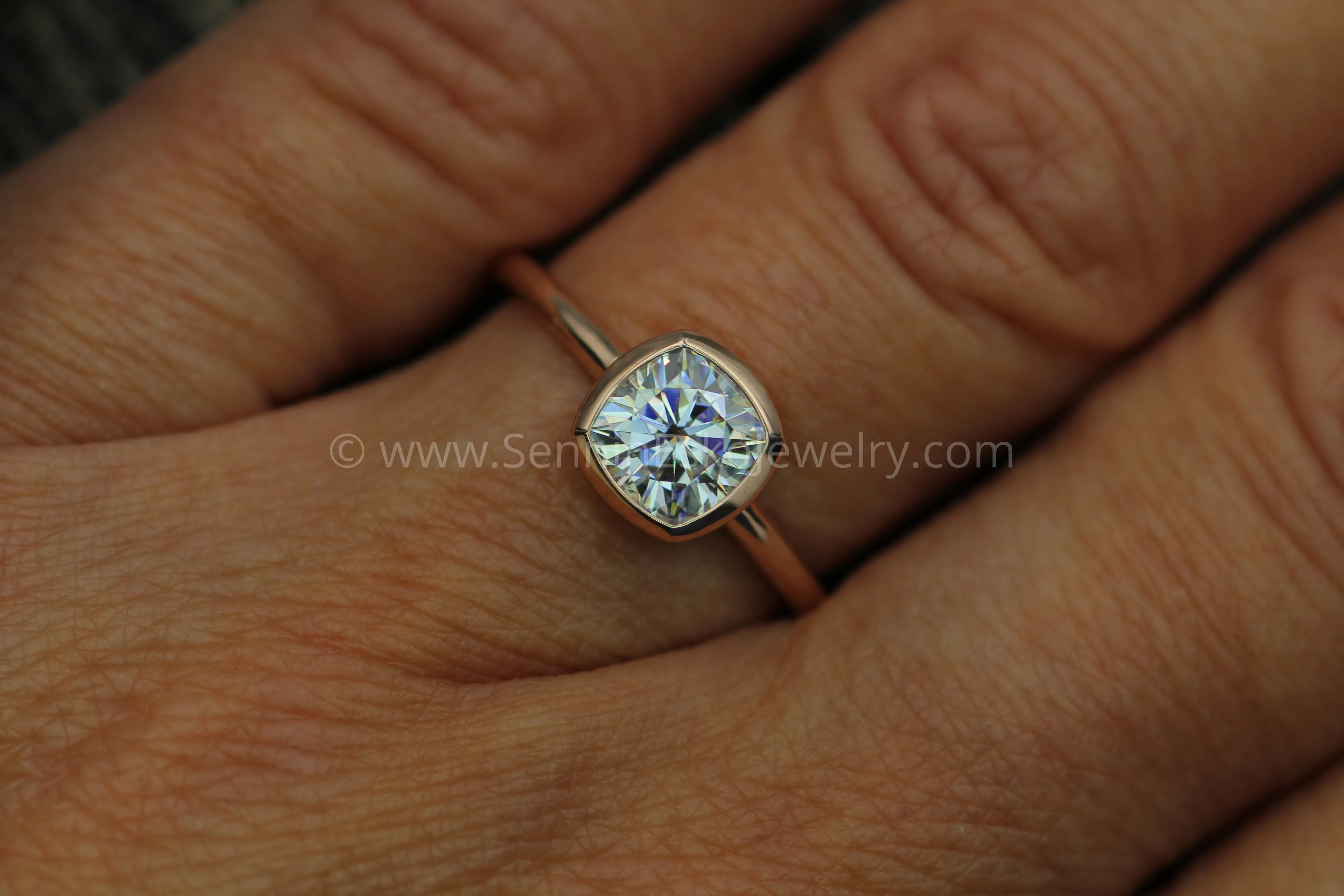 Colorless Moissanite 6x6mm Cushion Cut Bezel Solitaire Ring With A Medium/Lightweight Band