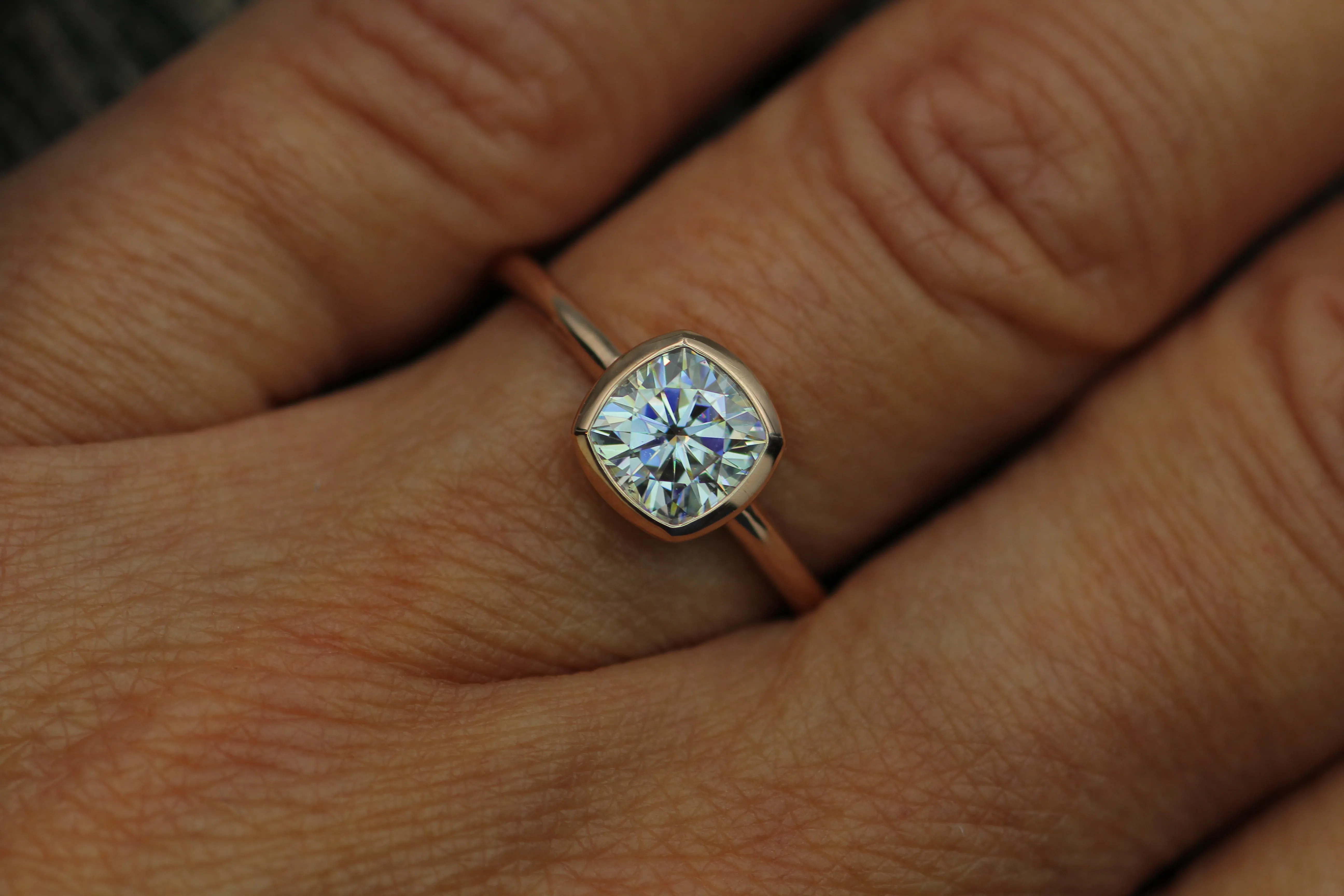 Colorless Moissanite 6x6mm Cushion Cut Bezel Solitaire Ring With A Medium/Lightweight Band