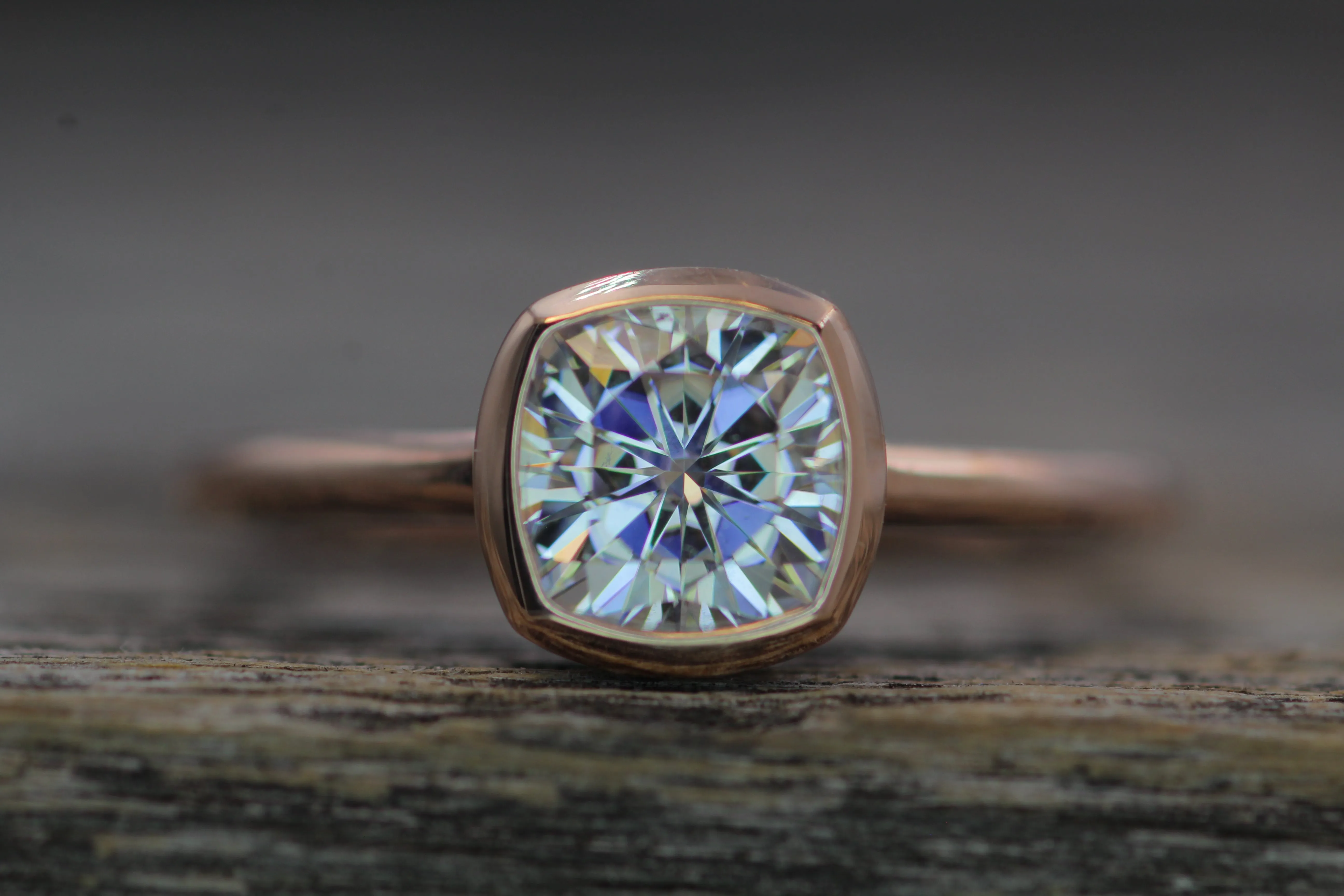 Colorless Moissanite 6x6mm Cushion Cut Bezel Solitaire Ring With A Medium/Lightweight Band
