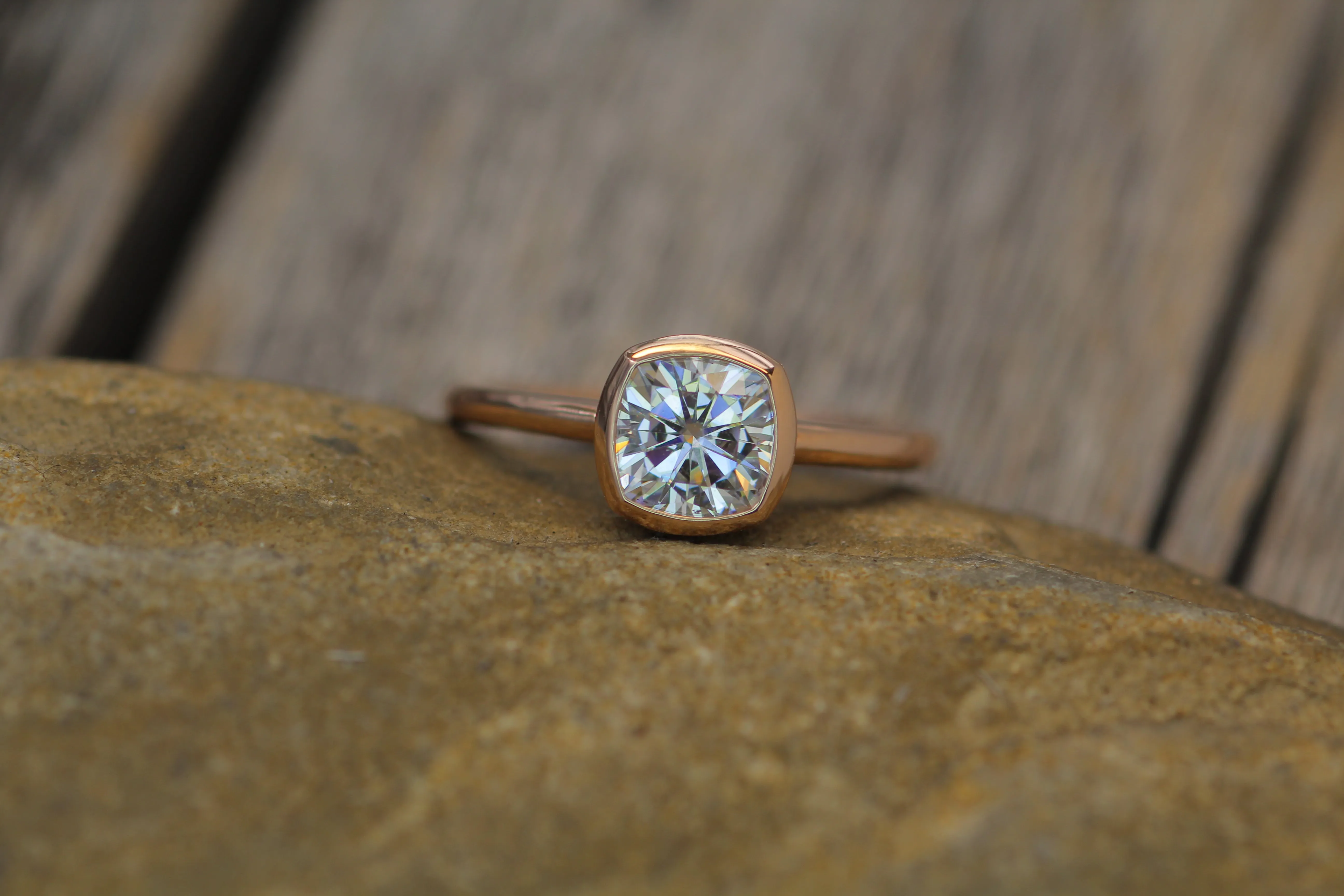 Colorless Moissanite 6x6mm Cushion Cut Bezel Solitaire Ring With A Medium/Lightweight Band