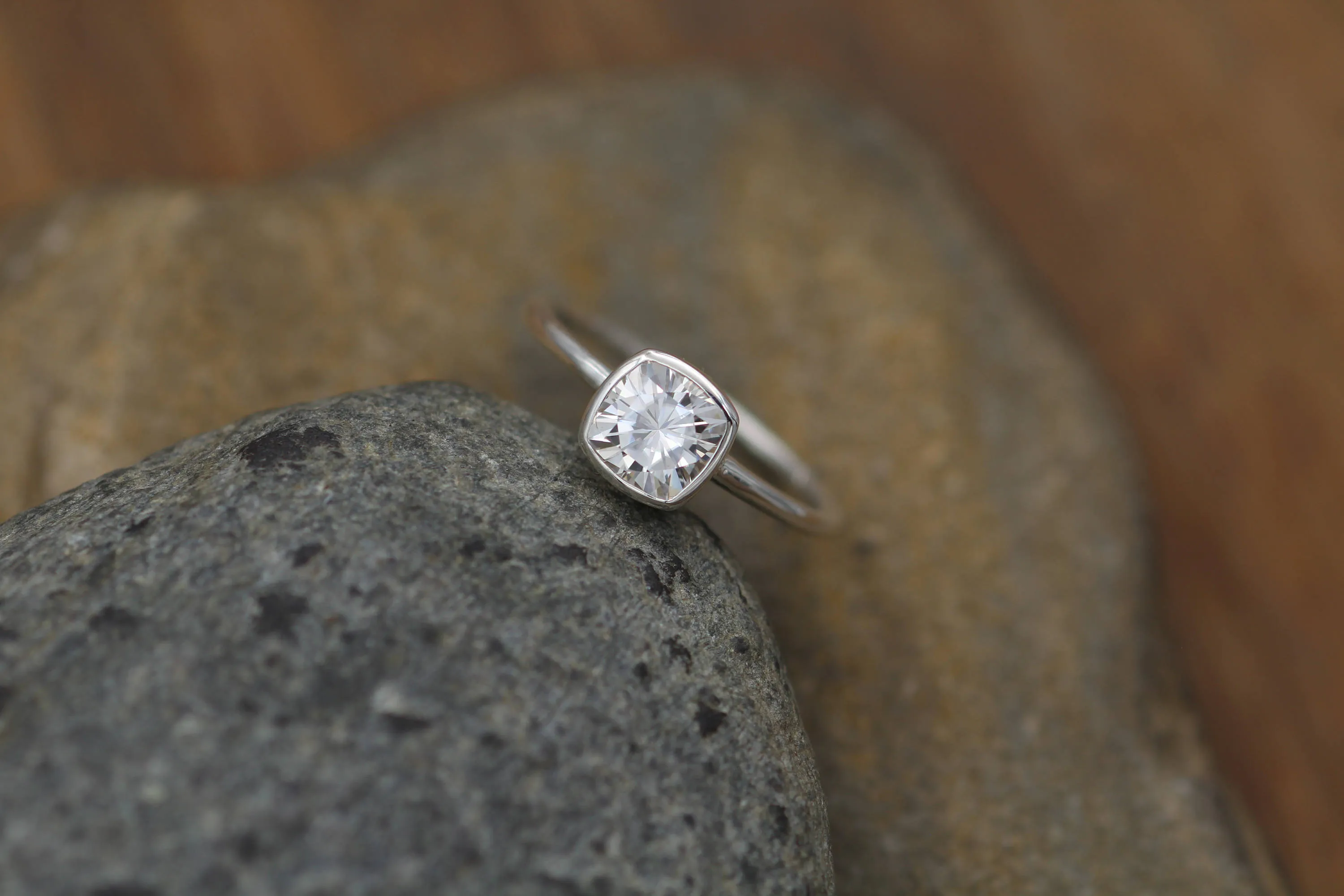 Colorless Moissanite 6x6mm Cushion Cut Bezel Solitaire Ring With A Medium/Lightweight Band