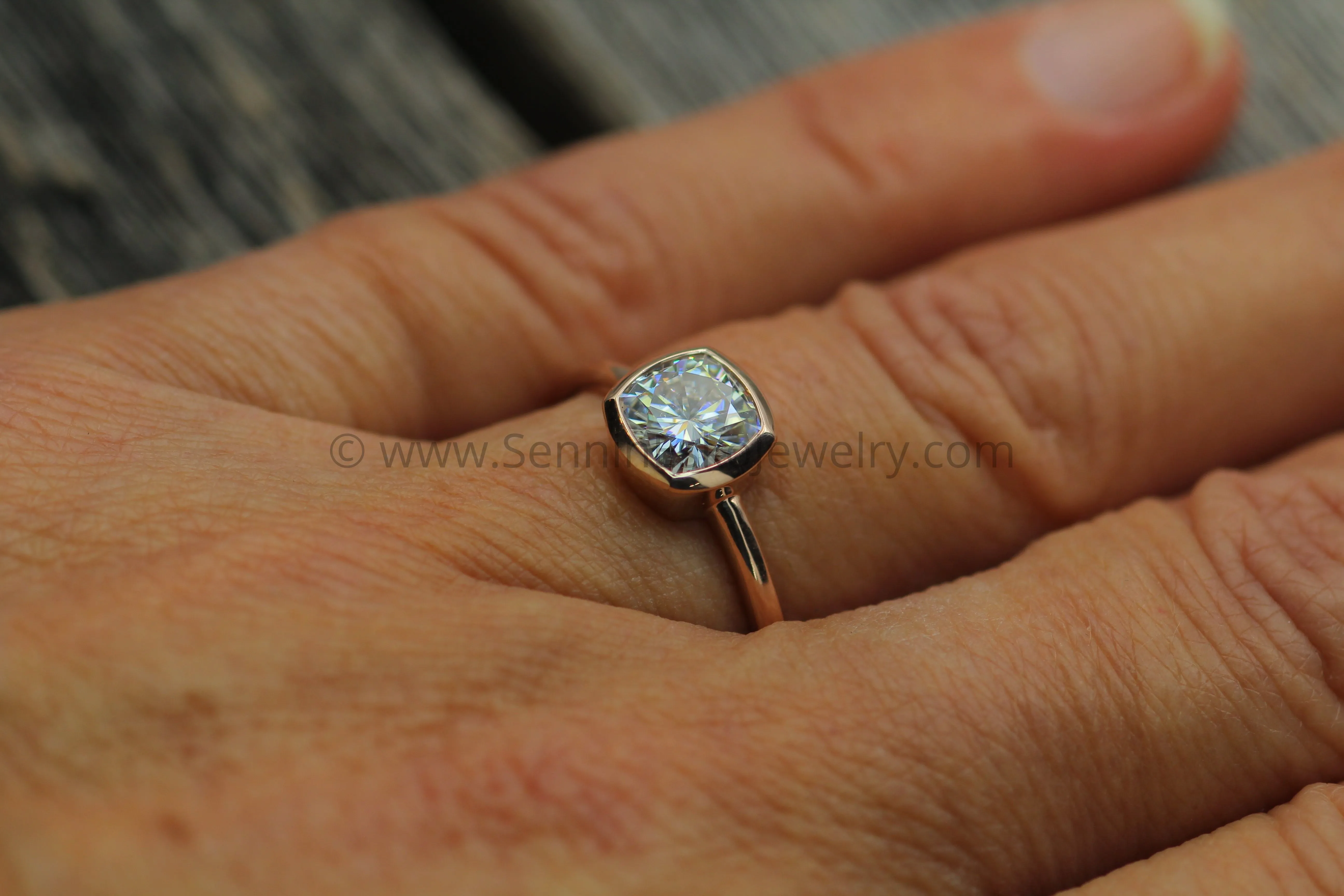 Colorless Moissanite 6x6mm Cushion Cut Bezel Solitaire Ring With A Medium/Lightweight Band