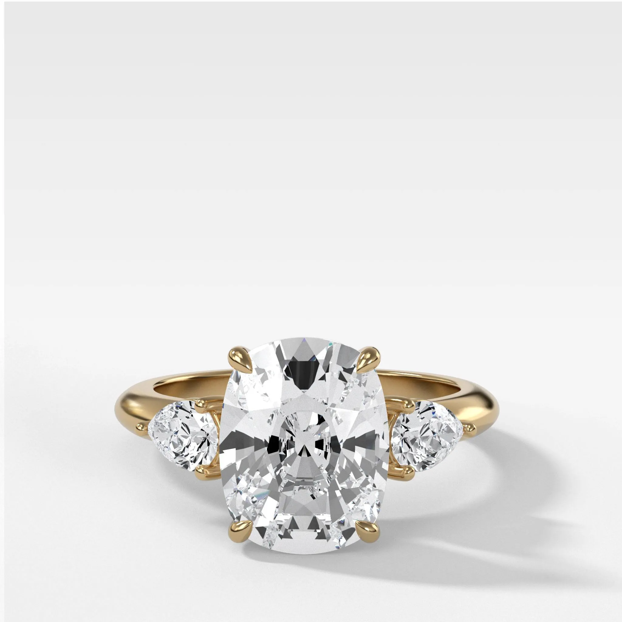 Three Stone Engagement Ring With Pear Side Stones and Elongated Cushion Cut Diamond